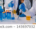 Medical or scientific researcher or man doctor looking at a test tube of clear solution in a laboratory 143697032