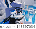 Medical or scientific researcher or man doctor looking at a test tube of clear solution in a laboratory 143697034