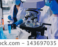 Medical or scientific researcher or man doctor looking at a test tube of clear solution in a laboratory 143697035