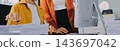 Two Asian business women looking at tablet and working together in office workspace. 143697042
