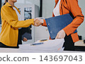 Two happy businesswomen collaborating in a modern office 143697043