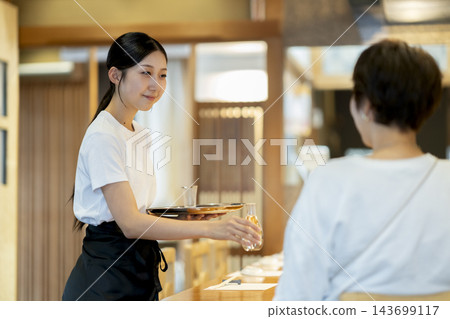在餐廳工作的年輕女服務員 在餐廳工作的年輕女服務員 143699117