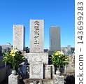 A stone monument marking the family's history and flowers offered as a memorial. 143699283