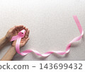Pink Ribbon Held in Hands for Breast Cancer Awareness 143699432