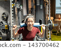 一名肩扛槓鈴的女子目不轉睛地盯著前方。 143700462