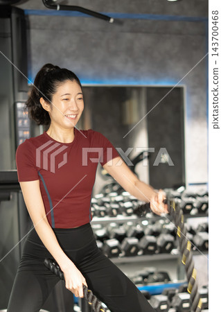 一名女子側身揮舞著戰繩。 一名女子側身揮舞著戰繩。 143700468