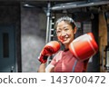 一名戴著紅色手套的女子揮拳，然後大笑起來。 143700472