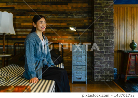 微笑的女人在床上放鬆 微笑的女人在床上放鬆 143701752
