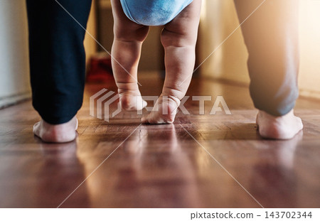 Person, baby and feet learning to walk house with parent support, trust and progress of mobility development. Family, child and teaching kid first steps, motor growth and helping balance at home Person, baby and feet learning to walk house with parent support, trust and progress of mobility development. Family, child and teaching kid first steps, motor growth and helping balance at home 143702344