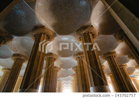 Rows of Doric columns and mosaic domes in the Hypostyle Room with bright exit, Park Guell Barcelona Rows of Doric columns and mosaic domes in the Hypostyle Room with bright exit, Park Guell Barcelona 143702757