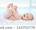 Happy, baby and portrait on bed for game, relax and development or learning in home. Child, wake up and smile in nursery for motor skills and face in morning for play, wellness and healthy for growth 143703776