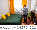 Older woman dancing to favorite melodies in peaceful room. Calm happiness and positivity. Concept of retirement comfort. 143704212