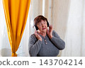 Senior Caucasian woman enjoying active leisure with music indoors. Freedom and cheerful mood. Concept of healthy senior routine. Mid shot 143704214