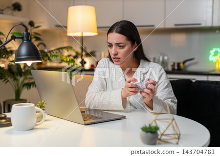 Young woman angry at utility bill crumples receipt throws papers worries about big charges evening Young woman angry at utility bill crumples receipt throws papers worries about big charges evening 143704781