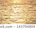 The surface of the water illuminated by the sunset 143704804