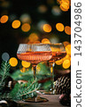 Elegant Rose Champagne Glasses with Christmas Lights and Holiday Decorations 143704986