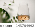 Rose Wine Glass with Tropical Palm Leaves and Soft Reflection 143704992