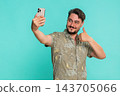 Man confidently smiling taking selfie with smartphone creating new photo for social media profile 143705066