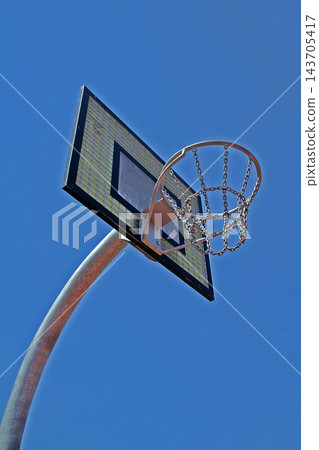Outdoor Basketball Hoop with Chain Net Against Blue Sky Outdoor Basketball Hoop with Chain Net Against Blue Sky 143705417