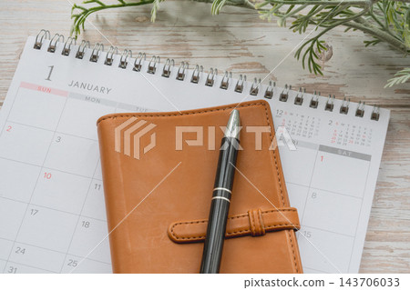一月份的日曆、一本真皮筆記本和一支筆——為新的一年開始,並製定人生計劃的目標做好準備。 一月份的日曆、一本真皮筆記本和一支筆——為新的一年開始,並製定人生計劃的目標做好準備。 143706033