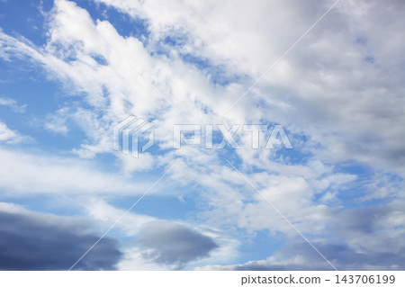White cumulus and wispy cirrus clouds spread across a blue sky. White cumulus and wispy cirrus clouds spread across a blue sky. 143706199