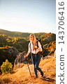 Woman hiking mountain path during autumn sunset 143706416