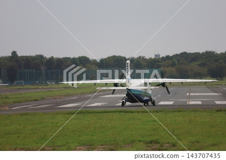 一架飛機駛入調布機場跑道,準備起飛前往神津島。 一架飛機駛入調布機場跑道,準備起飛前往神津島。 143707435