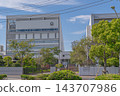 Exterior view and main gate of Shibuya Education Academy Makuhari Junior and Senior High School, against a blue sky [Wakaba, Mihama Ward, Chiba City, Chiba Prefecture] 143707986