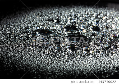 Morning Dew Pure water droplets on a dark surface tension. Water drops rolling off waterproof coating surface tension physics detail clean background, Macro Photography 143710022