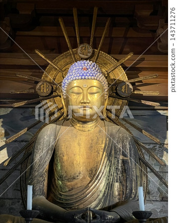 一尊金色的坐佛像，背後有光環。 143711276