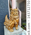 A caramel-colored Shisa sitting on top of a gatepost 143712750