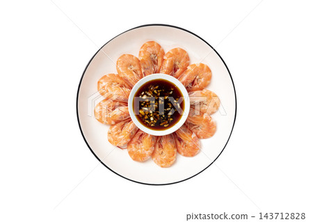 Boiled whole shrimp arranged in a circle on a white plate with garlic soy dipping sauce, top view isolated on white background 143712828