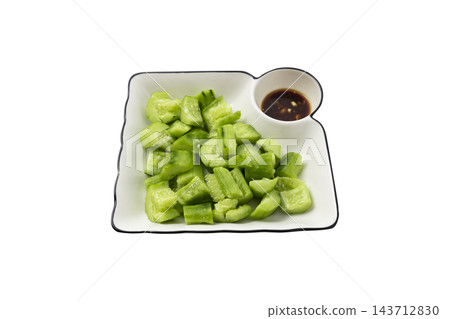 Smashed cucumber salad with savory dipping sauce on a white ceramic plate, isolated on a white background Smashed cucumber salad with savory dipping sauce on a white ceramic plate, isolated on a white background 143712830