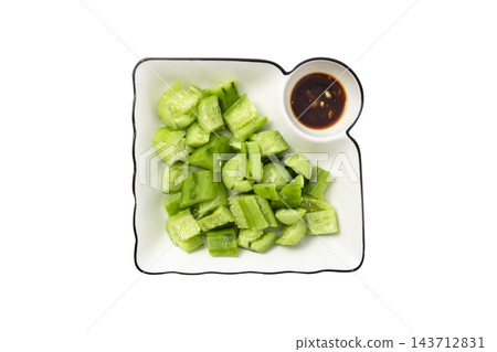 Top view of fresh smashed cucumber salad with a side of soy sauce dipping sauce on a white plate, isolated on a white background Top view of fresh smashed cucumber salad with a side of soy sauce dipping sauce on a white plate, isolated on a white background 143712831