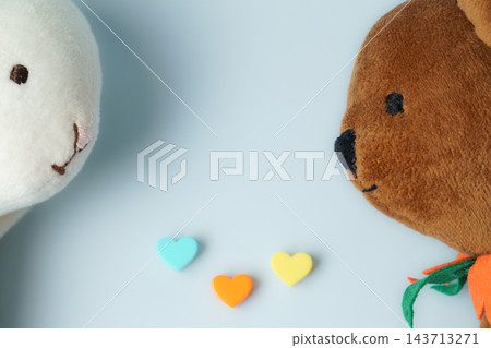 Plush animals looking at colorful hearts representing love 143713271