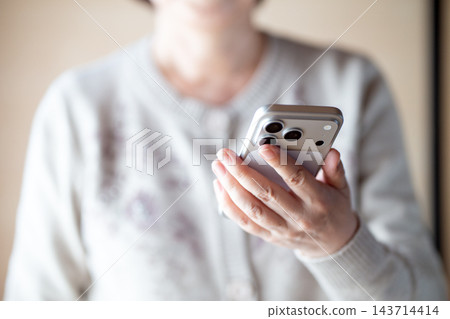 擁有智慧型手機的中老年女性 擁有智慧型手機的中老年女性 143714414