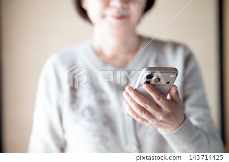擁有智慧型手機的中老年女性 擁有智慧型手機的中老年女性 143714425