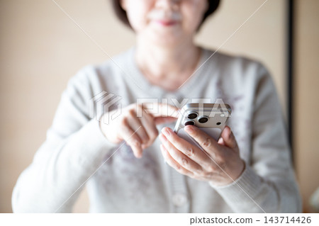 擁有智慧型手機的中老年女性 擁有智慧型手機的中老年女性 143714426