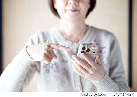 中老年女性指著她們的智慧型手機 中老年女性指著她們的智慧型手機 143714427