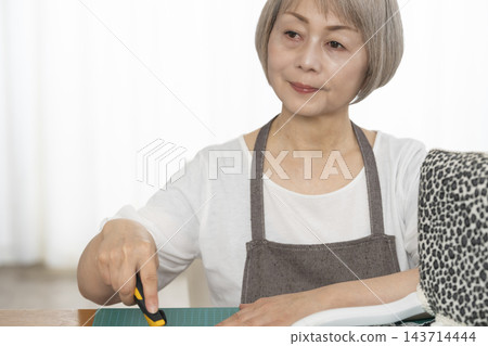 一位老婦人在客廳裡改造了一個娃娃椅，作為她的DIY愛好。 143714444