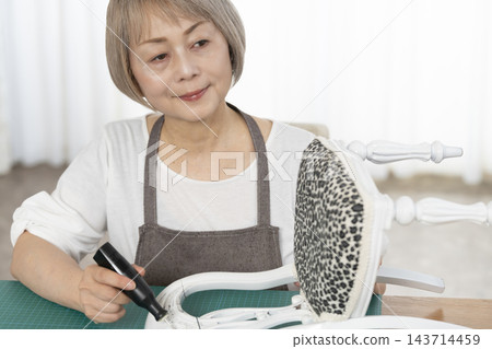一位老婦人在客廳裡改造了一個娃娃椅，作為她的DIY愛好。 143714459