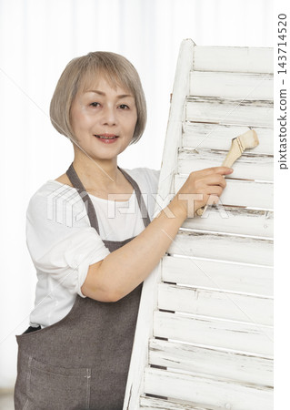 一位老婦人在客廳裡製作椅子，這是她的DIY愛好。 143714520