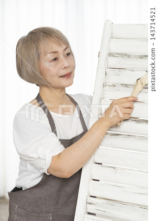 一位老婦人在客廳裡製作椅子，這是她的DIY愛好。 143714521