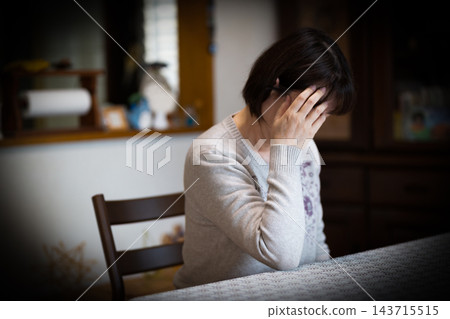 中老年婦女在家中客廳感到煩惱 143715515