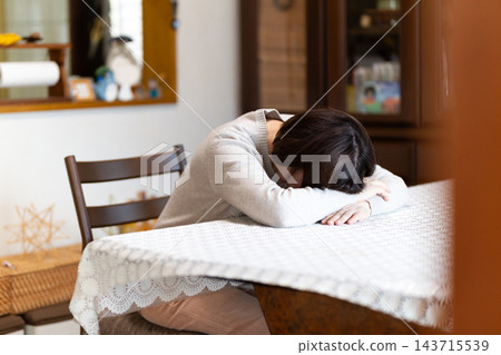 中老年婦女在家中客廳感到煩惱 中老年婦女在家中客廳感到煩惱 143715539