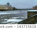 River Embankment With Ice Floes and City Buildings Along Winter Waterfront 143715618