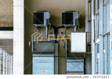 HVAC Air Conditioning Units and Metal Ductwork Mounted on Building Exterior Wall HVAC Air Conditioning Units and Metal Ductwork Mounted on Building Exterior Wall 143715621