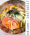 特寫鏡頭展現了清爽冰涼的韓國冷面，裡面鋪滿了各種食材。 143716517
