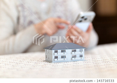 中老年女性在客廳和家中查看智慧型手機 中老年女性在客廳和家中查看智慧型手機 143716533