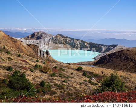 The Yugama crater lake and crater wall of Mount Kusatsu-Shirane, shimmering with emerald green light. The Yugama crater lake and crater wall of Mount Kusatsu-Shirane, shimmering with emerald green light. 143716612